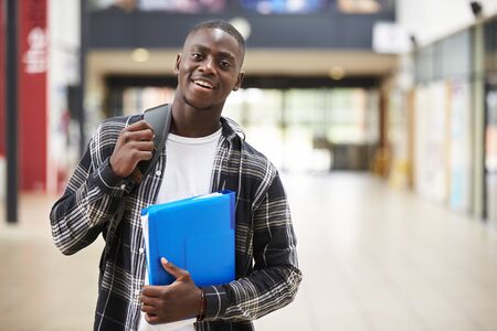 91579645-portrait-of-male-student-standing-in-college-building